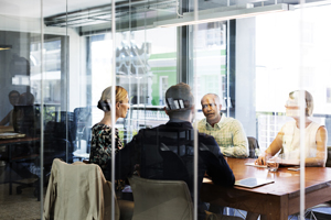 A meeting happening in a conference room surrounded by Commercial Glass in Kewanee IL