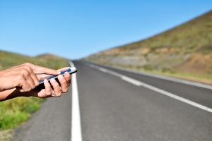 Man calling someone on his cellphone, stranded on the side of the road