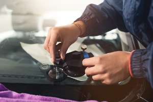 A technician performing Auto Glass Service in Kewanee IL on a windshield