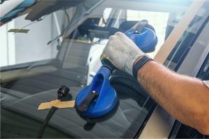 A team member of Glass Specialty WLC begins performing a car Window Replacement in Galesburg IL