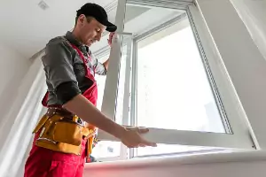 A team member of Glass Specialty WLC installs a window in a home, which is one of the options the team can offer in addition to Commercial Glass in Galesburg IL.