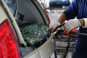 A team member of Glass Specialty WLC clears out broken class from the back of a mini van. Auto glass repairs and replacements are one of the options Glass Specialty WLC offers in addition to Commercial Glass in Monmouth IL.